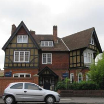 92 Woodstock Road Photo of the exterior of tudor-style building 92 Woodstock Road, with a silver car in the foreground
