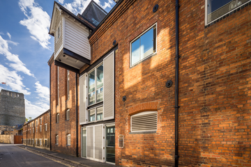 The Malthouse Photo of the exterior of the Malthouse, a red brick building with white shutters on the front